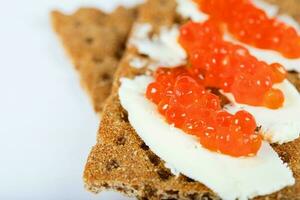 Cereal crispbread crackers with butter and red caviar. photo