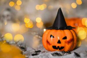 Orange pumpkin in a black witch hat. Spooky background. photo