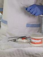 Sterile cotton napkins, human jaw model and stomatological tools on a table. photo