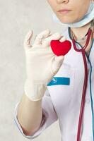 A red plush heart in the hand of a doctor photo