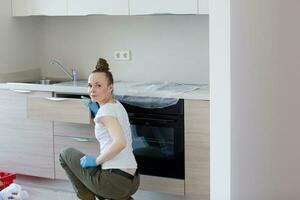 Young lady stays in front newly installed kitchen photo