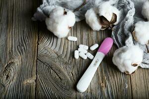 Contraceptive pills and condom on a wooden surface., Contraceptive pills and pregnancy test on a wooden surface. photo