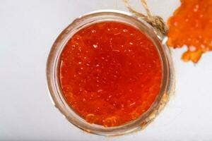 Red caviar in the glass bottle. photo