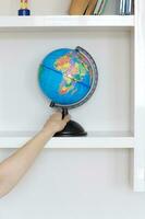 Colorful paper globe on a book shelf. photo