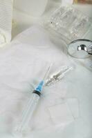 Syringe, alcohol wipe and glass ampule with antibiotics on a white napkin.Top view photo