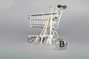 Bitcoin and shopping cart with tools in the background. photo