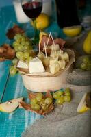 queso rebanadas, pera, y uvas en un de madera pararse. foto