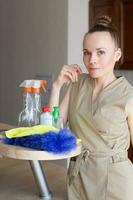 Young cleaning lady stays in the kitchen. Closeup photo