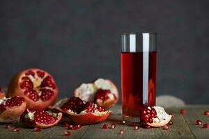 Glass of pomegranate juice on a wooden surface. photo