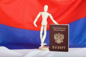 Russian pass and wooden dummy figurine on Russian flag. photo