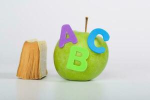 Apple and small book. Closeup photo