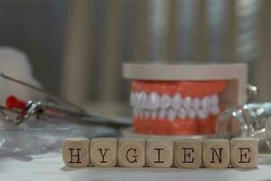 palabra higiene compuesto de de madera dados. pastillas, documentos, bolígrafo, humano mandíbula modelo en el antecedentes. foto