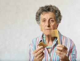 Senior woman and a broken wooden made hair comb photo