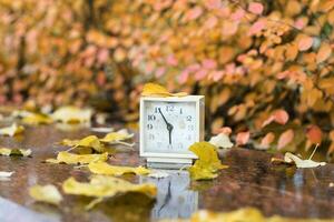 antiguo cuadrado alarma reloj en un mármol Roca cubierto por lluvia. foto