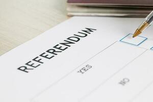 Referendum ballot paper, black pen, and passport on the table. photo