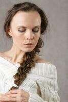 Young lady dressed in knitted sweater. Closeup photo