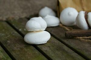 Italian meringue on an old wooden surface. photo