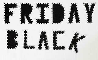 Words BLACK FRIDAY are cut out from black carton paper. photo