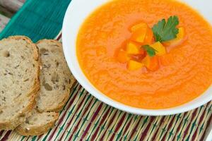 A plate of carrot soup with fresh pasley photo