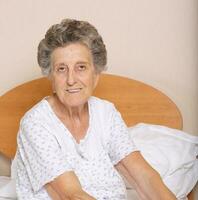 Senior woman is sitting in her bed photo