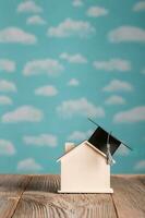 Black square academic cap on a handmade small house., Academic hat on a small wooden house. photo