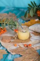 Rowan berries, glass with honey and honeycomb on a sackcloth. . photo