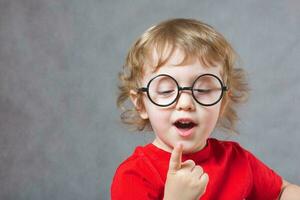 A boy shows his index finger photo