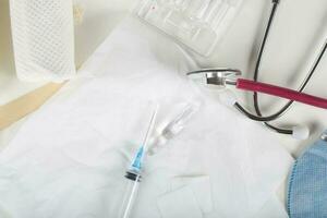 Syringe, alcohol wipe and glass ampule with antibiotics on a white napkin.Top view photo