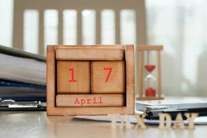 Wooden calendar behind composed letters TAX DAY. photo