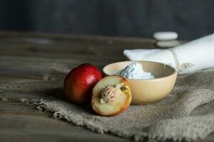 Peach seeds facial mask in a clay pot. photo