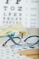 Eyeglasses for children on a eye chart close to eye pads. photo