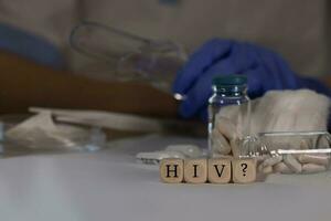 Abbreviation HIV for human immunodeficiency viruses with question mark  composed of wooden dices. Pills, documents and a pen in the background. photo