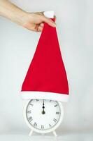 Vintage alarm clock in Santa Claus hat. photo