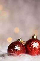 Red blazing Christmas balls on white artificial fur. Extreme closeup. photo