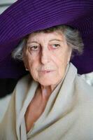 Old caucasian woman in a violet hat photo