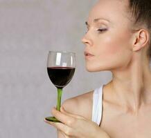 Young lady keeps a glass of red wine. photo