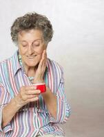 Senior woman with a box of face cream photo