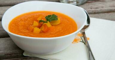 un plato de Zanahoria sopa con Fresco pasley foto