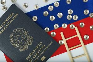 Pins,service pass of an European official written in Italian and mini wooden made ladder on a Russian flag. Background photo