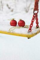 Christmas balls in the snow on a swing seat photo