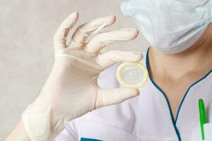 Condom in the hand of a doctor. photo