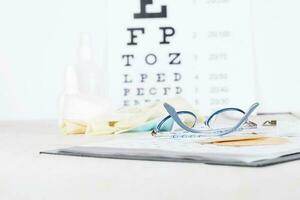 Eyeglasses for children on a eye chart close to eye pads. photo