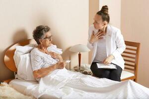 Visit of senior social work assistant to an old woman photo