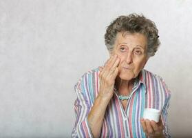 Senior woman with a box of face cream photo