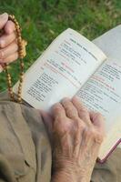 An open franciscan prayer book in Italian language and anglican prayer beads with cross photo