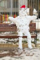 Handmade snowman with red hat made from natural snow photo