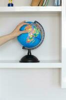 Colorful paper globe on a book shelf. photo