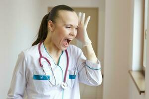 Stressed young doctor in the corridor of a clinic photo