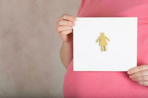 Young pregnant between 30 and 35 years old woman keeps a  blank white sheet of paper. photo