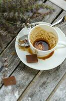 A dirty cup after coffee on a wooden surface. photo